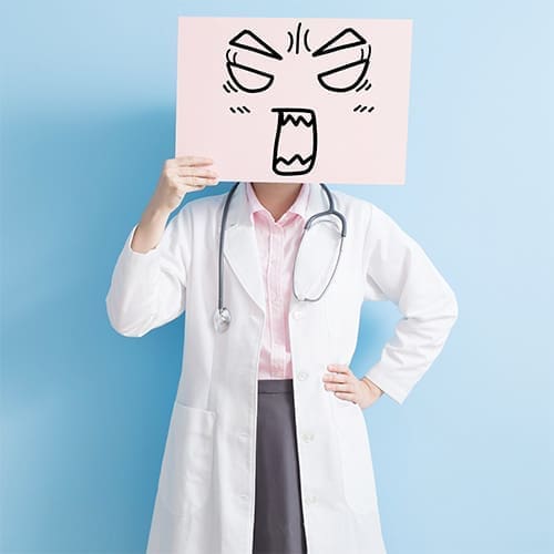 a poster with an angry face is held in front of a doctor